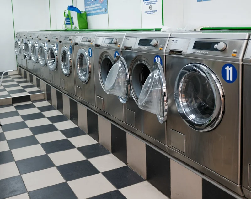 Fila di lavatrici industriali in una lavanderia